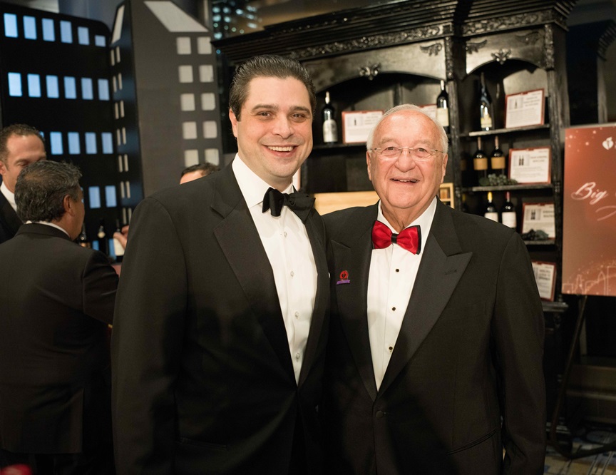 Two men in tuxedos standing together in the reception area.
